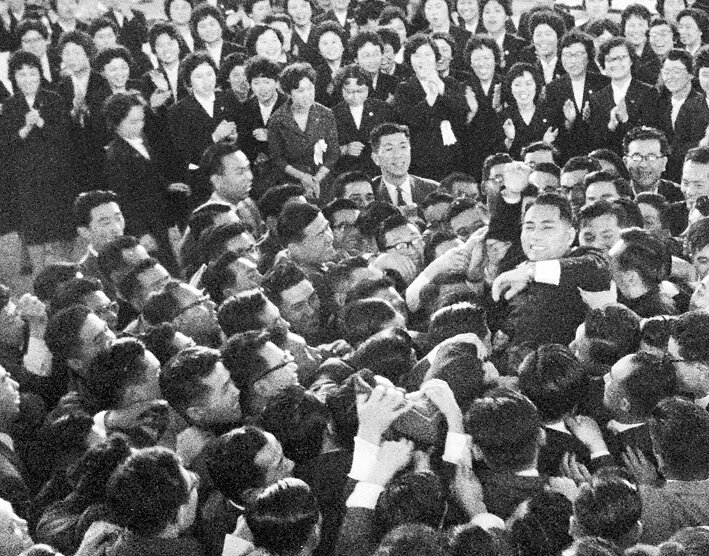 Após o término da cerimônia de posse presidencial, membros da Soka Gakkai carregam Daisaku Ikeda (3 maio 1960)