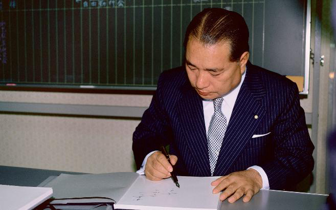 O presidente Ikeda escreve palavras de incentivo em um livro. “Se houver este único instante”, diz ele, sem poupar nem um momento sequer para transmitir coragem aos amigos (Centro Cultural de Chiba, 26 out. 1980)